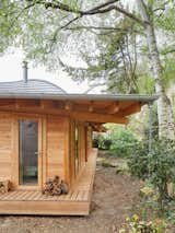 The sloping metal roof extends well beyond the house and the narrow deck that runs around it. “The roof protects from the sun and the rain and also creates shadow,” says Barache, adding that “beauty is in the shadow.”