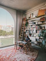 Despite the loft’s derelict condition, its 14-foot ceilings and enormous windows instantly appealed to Gabriele. His home workspace looks out on a soccer field and open views of the Bellvitge neighborhood. The Losanges rug is by Ronan &amp; Erwan Bouroullec for Nanimarquina.