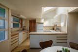 The skylit corner kitchen is fitted with an abundance of cabinetry and counter space.