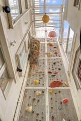 An 83-foot-high rock-climbing wall—complete with a harness system—sits between the two volumes.
