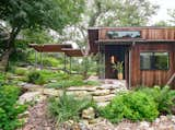 This West Austin retreat, originally designed in the 1980s by renowned architect Robert Renfro, sits on a secluded hillside with a ravine and stream. The thoughtful renovation and addition combines a reverence for postmodernist ideals with a commitment to contemporary amenities.