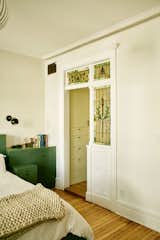Katie and Bruce love color, which they injected into almost every room. Built-in furniture in the primary bedroom is painted in Benjamin Moore’s Enchanted Forest, and cabinetry in the closet is covered in greenish-yellow Dark Linen, also from Benjamin Moore.