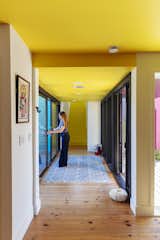 Spread across two lots, the house has two wings: One acts as a more private, residential area, and the other is a communal living space. The designers sought to create “small, private, comfortable homes that were then tied back to a space for gathering, performance, creation, and events,” says architect James Carse, cofounder of Alao. Missy stands in the hallway that connects the two sides and opens onto an outdoor seating area and a garden designed by Garden Gnome Plantscapes.