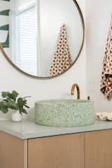 The Pacifica Quietude extra small marble chip slabs used as vanity top match the Venice tiles on the shower floor. The sink is the Bondi Sink in Pistachio Medium Marble Chip, also made by Concrete Collaborative.