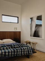 A ceramic piece by Kevin Willis sits on the nightside beside an antique indigo boro cloth sourced from Japan. The metal sconces are from Linchen.