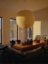 An Akari pendant from Isamu Noguchi hangs above the living room. The table and stools are from Ah Um Design Studio.