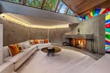 Stained glass accents and a monolithic hearth adorn the large living area.