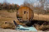Wood barrel sauna sits outside in a geodesic dome by FDomes with an interior designed and built by SpotLab in Lost Woods glamping site situated in Boyne Falls, Northern Michigan.