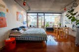 The living space has a Hästens bed that can fold away during parties, a dining table and chairs by Alvar Aalto, and track lighting in the apartment’s signature orange.