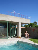 Architect Ezequiel Adelmo Manasseri sits by the pool in front of the 538-square-foot home he and María Sol Depetris designed for the resident, Emilia.  Photo 6 of 11 in Pops of Color and a Concrete Cube Make This Argentina Retreat Like “a Ball Pit for Grown-Ups”