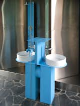 The small square bathroom has floor-to-ceiling mirrors and frosted-glass windows. Emi admits this might be off-putting for guests, but her focus for the house was to serve her personal needs when she’s there alone, to feel unrestricted and open. The custom baby-blue sheet-metal sink is designed by Manasseri Depetris.  Photo 7 of 11 in Pops of Color and a Concrete Cube Make This Argentina Retreat Like “a Ball Pit for Grown-Ups”