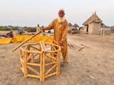 A man demonstrates the simple skeleton of Lari’s eight-sided bamboo homes.