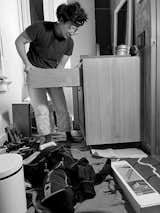Black-and-white photo of woman inserting drawer into cabinet during construction in a Victorian home in Providence, Rhode Island, renovated by Emily Lindberg Design and Work in Use.