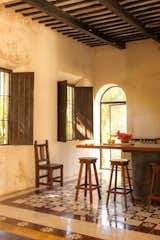 The wood-beamed kitchen features an island built atop a repurposed water boiler.