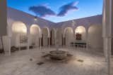 The home’s courtyard has a central fountain and covered walkways framed by arch motifs.