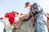 Cliff Douglas and his daughter, Devon, remove tiles from a fireplace in Altadena.