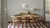 The table is made of clear acrylic lacquered solid wood with an oak veneer, and is surrounded by chairs of the same—plus a leather seat cushion.