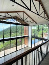 In the double-height living room, west-facing floor-to-ceiling windows offer views of the surrounding valley.