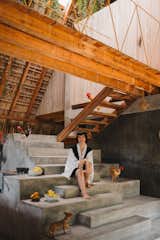 Deborah sits on the concrete staircase at the center of the house. Doubling as an extension of the kitchen, it encases a stove, a refrigerator, and storage space. “These stairs for me are like sculpture that you can use,” says the Venezuelan-born artist. “They’re a cross between art and functionality.”