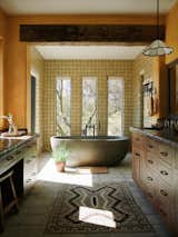 The tiles in the primary en suite are individually hand-painted, celebrating the same sense of craft as the organic architecture. "Nothing is perfect and that is what gives this kind of Santa Fe architecture such beauty," says Kelly. Michelle decided to replace the original single large picture window with three tall windows to create a better rhythm in the space.
