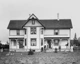 A 1899 photo of a family standing on the front porch of their Wisconsin home.