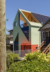In addition to its curved powder-blue cabinets to its bold cutouts and red-tiled entrance, the front facade presents its own set of oversize cutouts. “We wanted to use pure geometries throughout the home,” says architect Marianne Amodio.