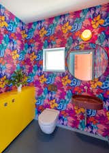 The powder room features a vibrant floral wallpaper that can also be found in Fluevog stores.