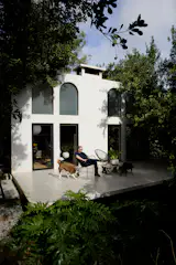 Floating steps lead to the main entrance, and a side patio has steps to a rooftop terrace.