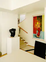 Untitled (Bessie Smith Head), a glass sculpture by Terry Adkins, and Njideka Akunyili Crosby’s The Beautyful Ones Series #2a are part of Roxana and Charles’s extensive collection. The works are in the mezzanine dining room, which looks out over the living area.