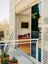 Sliding doors open to the balcony off the enlarged living room where a work by Sol LeWitt hangs. When the panels went up, the house became a curiosity in the neighborhood. “People actually stand in front of it and try to figure it out,” says Roxana. Charles adds: “This guy that we’d been neighbors with for probably eighteen years at that point—we never said a word to each other. But when the new stairs were built, he came over and started talking about how much he loves them.”