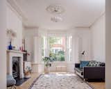 Alex and Jean filled the living area with furniture from their previous homes. New double-glazed timber-sash windows and custom shutters—a £38,000 splurge—flood the space with light.