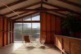 The garden pavilion is minimally furnished with two Nychair X seats, an Armadillo rug, and a vintage storage unit brought from Barcelona.