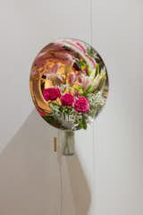 The stainless steel cone reflects and distorts the flowers it contains.