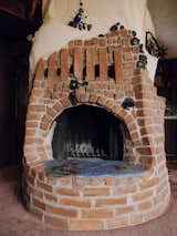A sculptural brick fireplace stands at the center of the home.