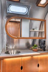 The bathroom has a spacious countertop and an asymmetrical mirror.