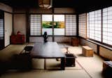 Large windows overlooking a courtyard garden in ceramist Kawai Kanjir<span style="font-family: Theinhardt, -apple-system, BlinkMacSystemFont, &quot;Segoe UI&quot;, Roboto, Oxygen-Sans, Ubuntu, Cantarell, &quot;Helvetica Neue&quot;, sans-serif;">ō</span><span style="font-family: Theinhardt, -apple-system, BlinkMacSystemFont, &quot;Segoe UI&quot;, Roboto, Oxygen-Sans, Ubuntu, Cantarell, &quot;Helvetica Neue&quot;, sans-serif;">’s house let in daylight that highlights the wood grains of the solid timber columns, beams, and furniture. </span>