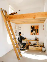 Aaron sits at a desk in the studio he added to the property, which contains an indoor workspace and a lofted sleeping area for visitors. One of Aaron's paintings hangs above the workbench. Not all works here are created indoors, however, nor are they solitary acts—not unlike how the property came together. “It was built as a collective effort,” Aaron says. “And it continues to be a collective space. A lot of friends come out and stay, and we work on stuff. I think the collaborative nature of my art practice is reflected in the build.”