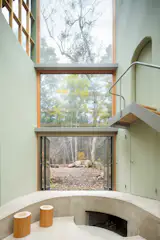A cave-like fireplace carved into the side of the sunken living room emphasizes the “primordial” feeling Mitsui says he was after.
