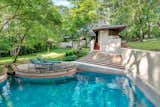 A set of stairs lead down to a pool with a circular patio.