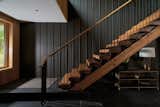 The sculptural, floating timber stair connects the home’s two volumes. Framed by exposed steel and lit from above, it creates a moment of weightlessness at the heart of the house.
