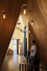 The lighting in the entry, and throughout the home, was designed and crafted by Braithwaite’s firm.  Photo 20 of 24 in This Clever Twist on an A-Frame Cabin? It Started in a Classroom from This Clever Twist On an A-Frame Cabin? It Started in a Classroom