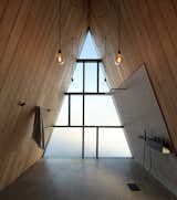 Private and public spaces were placed at opposite ends of the home, which “<span style="font-family: Theinhardt, -apple-system, BlinkMacSystemFont, &quot;Segoe UI&quot;, Roboto, Oxygen-Sans, Ubuntu, Cantarell, &quot;Helvetica Neue&quot;, sans-serif;">created this spacious, spa-like washroom,” says Braithwaite.</span>  Photo 12 of 23 in This Clever Twist on an A-Frame Cabin? It Started in a Classroom from This Clever Twist On an A-Frame Cabin? It Started in a Classroom