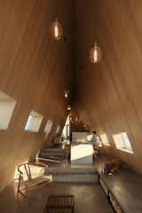 The shared spaces step down and widen as guests make their way through the home.  Photo 14 of 24 in This Clever Twist on an A-Frame Cabin? It Started in a Classroom from This Clever Twist On an A-Frame Cabin? It Started in a Classroom