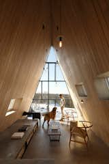 Facing south, the living space’s glass wall brings in light, creating a passive thermal heating system.  Photo 15 of 23 in This Clever Twist on an A-Frame Cabin? It Started in a Classroom from This Clever Twist On an A-Frame Cabin? It Started in a Classroom