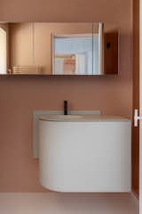 Clad in muted tones and softened by subtle textures, the guest bathroom carries through the home’s understated aesthetic, with just enough detail to feel luxurious. A custom Corian cabinet in Seagrass and a Gessi Tortona faucet add a refined, modern touch.