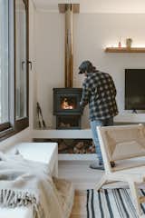 Facundo adds some logs to the standalone fireplace. The microcement niche below it is something he designed “on the fly” during the seven-month construction.