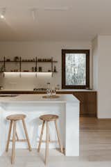 These three-legged timber stools are from Life Interiors, an Australian company where Ochoa bought most of the furniture. The island has a white Dekton countertop.