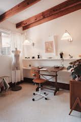 Dated yellow walls were given a fresh coat of white paint to freshen up a spare room that serves double duty as a design studio and a playroom.