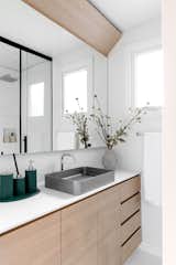 White finishes and light wood make the bathroom bright.