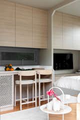 The bedroom has a row of overhead built-ins that match those in the kitchen.